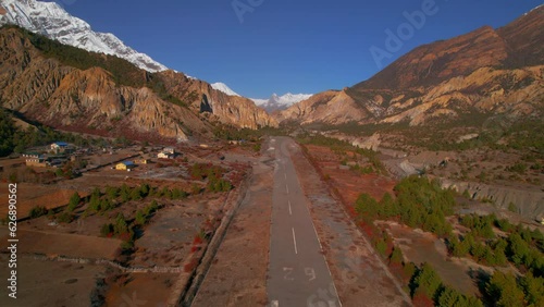 Aerial fly over popular Humde airport asphalt runway with mountains background.Transportation Nepal. Annapurna trek, Manang valley, Manang district, Gandaki zone, Nepal Himalayas. photo