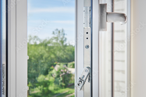 PVC window frame open closeup view. Lock window frame detail. Room open window ventilation. Mechanism of white plastic window sash. Plastic window profile inside