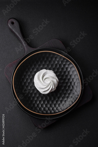 Delicious sweet colored marshmallow on a dark concrete background