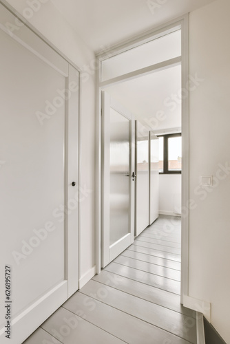 an empty room with white walls and wood flooring the door is open to let in light into the room