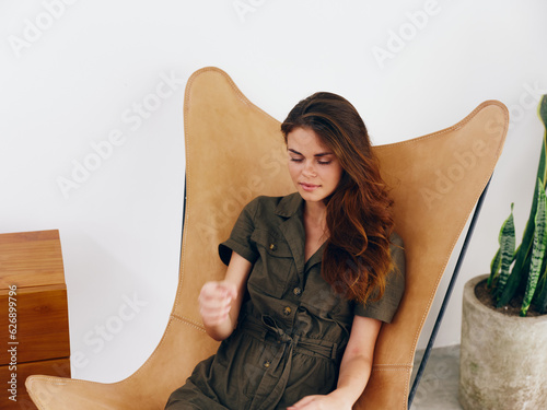 Woman sitting on a chair at home beautiful smile, fun and relaxation, modern stylish interior scandia lifestyle, copy space. photo