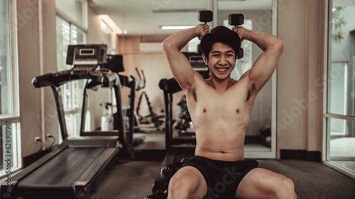 Muscular Young Man Exercising with Dumbbells in Gym - Strength Training and Fitness Concept, Active Gym Workout, Fitness and Determination.