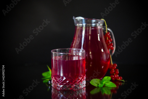 Cold refreshing drink from fresh summer berries in a decanter.