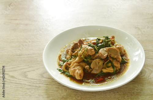 spicy stir-fried chili chicken meat and gizzard with basil on plate