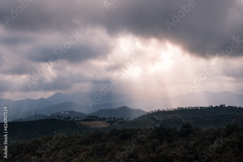 Rays of light through the clouds illuminate the mountains in Italy © Alex