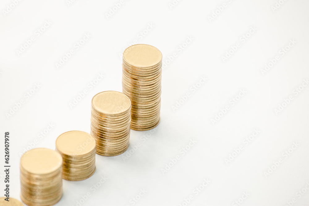 Stack of coins on white table. Graph or chart for investing in stock market. Gold management for wealth. Stack of coins on white table. Graph or chart for investing in stock market. Gold management for wealth.