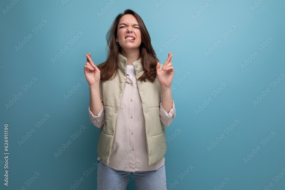 concentrated caucasian young brunette woman in casual clothes hopes on studio background concentrated caucasian young brunette woman in casual clothes hopes on studio background