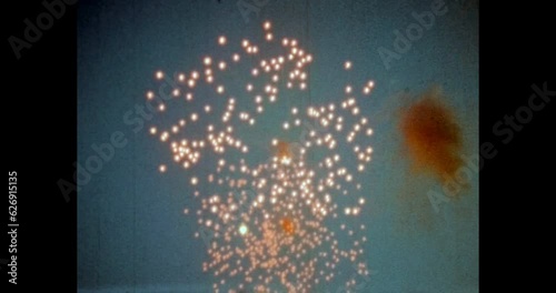 Fireworks in blue sky on city evening embankment. Fire works light show near city river, on city view backdrop. Red Square. Old retro 1980s Moscow, Russia. Archival vintage color film. Archive video