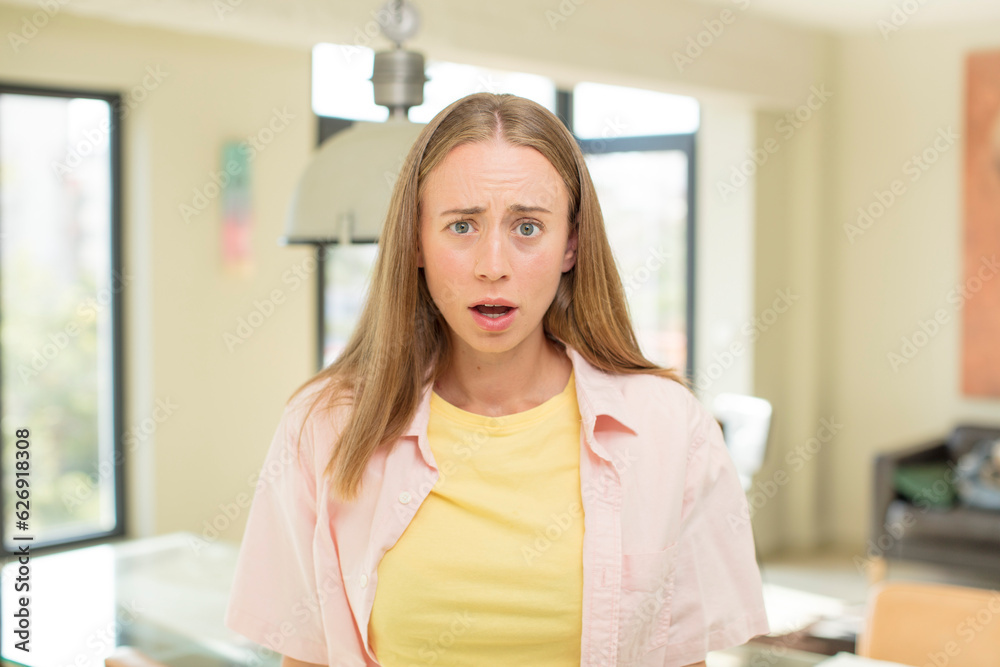 pretty blond woman feeling terrified and shocked, with mouth wide open in surprise pretty blond woman feeling terrified and shocked, with mouth wide open in surprise