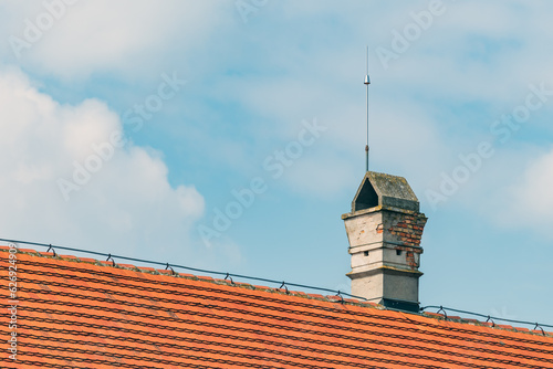 Chimney on the roof with lightning rod photo