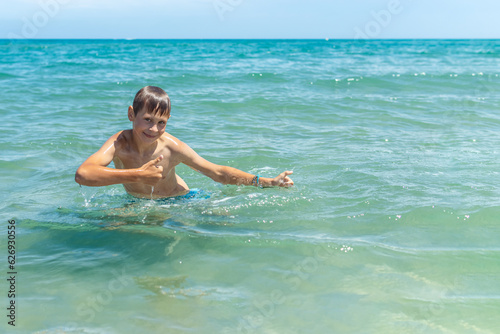 Happy boy swims and dives under water Active healthy lifestyle, water sports, seascape with a child