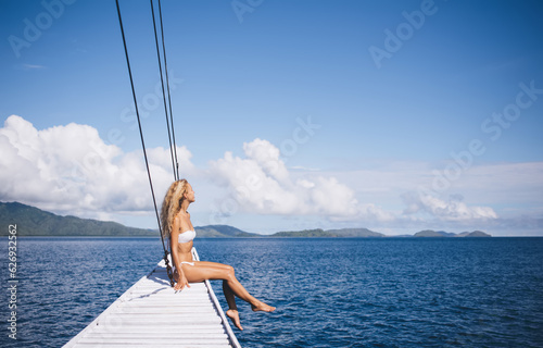 Bond haired woman resting on pier near sea