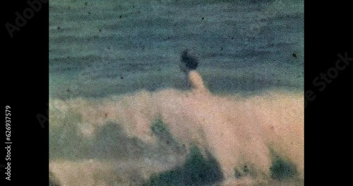 Little boy having fun, swimming in blue sea. Active child playing in sea waves in sunny summer beach. Holiday on ocean. Happy childhood. Archival vintage color film. Archive video. Old retro 1990s