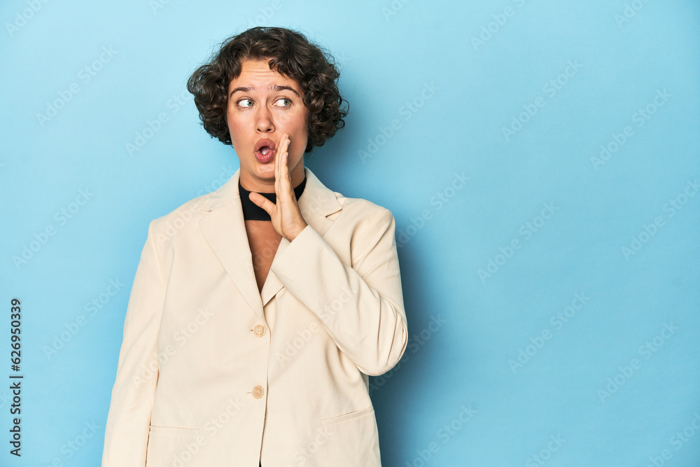 Young woman in elegant white blazer is saying a secret hot braking news and looking aside