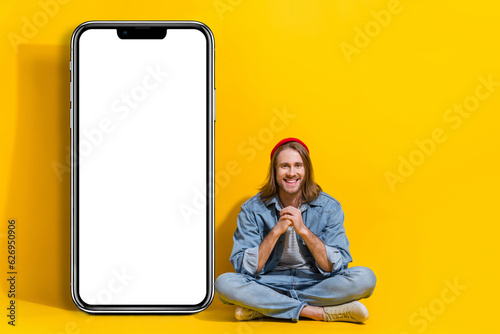 Full length photo of funny pretty man wear denim chatting modern gadget emtpy space isolated yellow color background