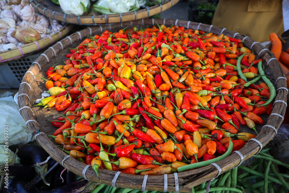 Piles of fresh hot peppers on display at the local farmers market. Freshly harvested hot pepper background.