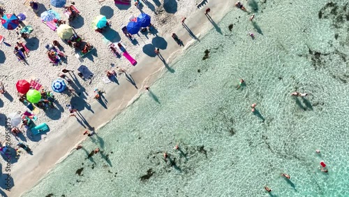 Aerial view on beach, people and umbrellas. Vacation and adventure. Europe, Mediterranean Sea. Top view from drone at beach and azure sea. View on the coast from drone. 