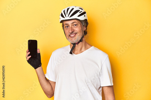 Cyclist man holding a phone, representing active lifestyle and technology.