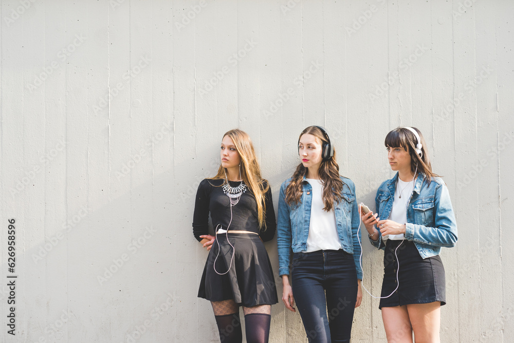 Fototapeta premium Three beautiful young women listening music