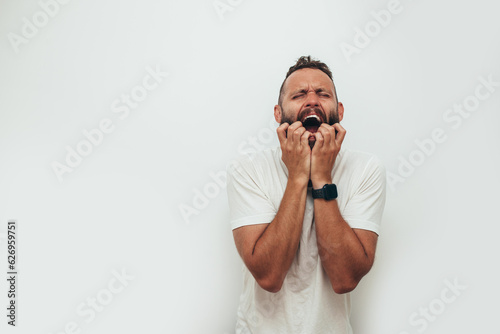 Homeless man drug addict and alcoholic sitting alone and depressed on the street, feeling anxious and tormented, social documentary concept