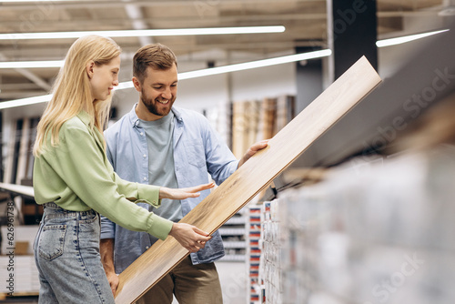Canvas Print Couple choosing laminate for floor at building market