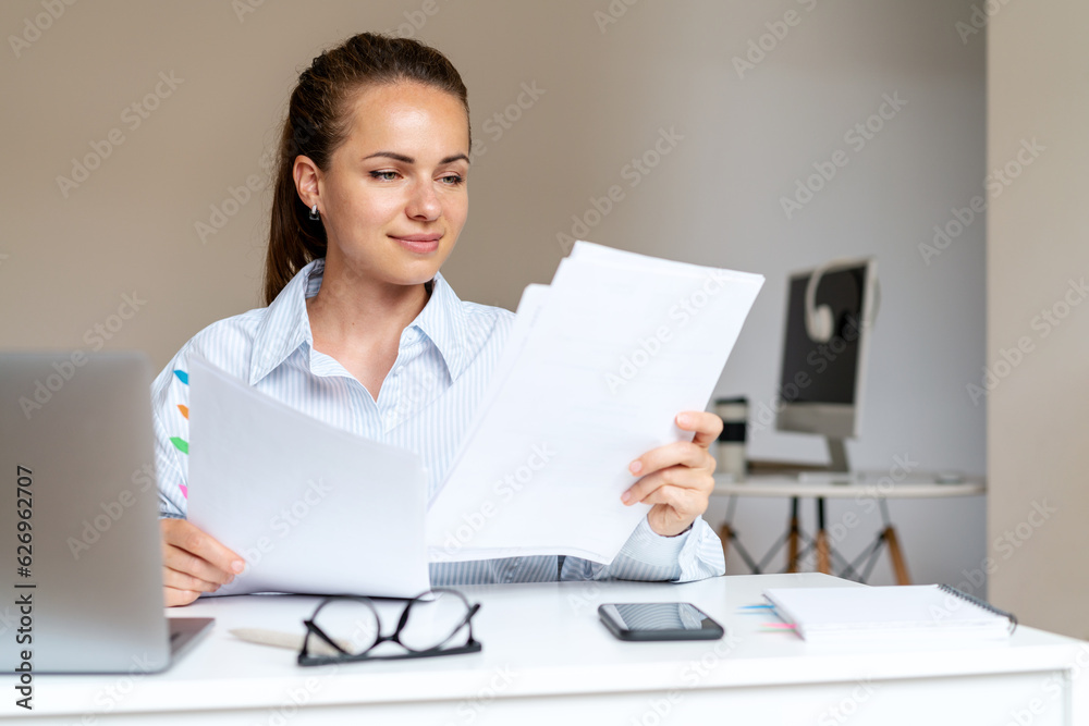 Brunette woman working with financial documents, businesswoman in office. Brunette woman working with financial documents, businesswoman in office.