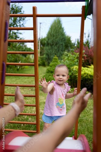 little baby girl with mother on slide in playground