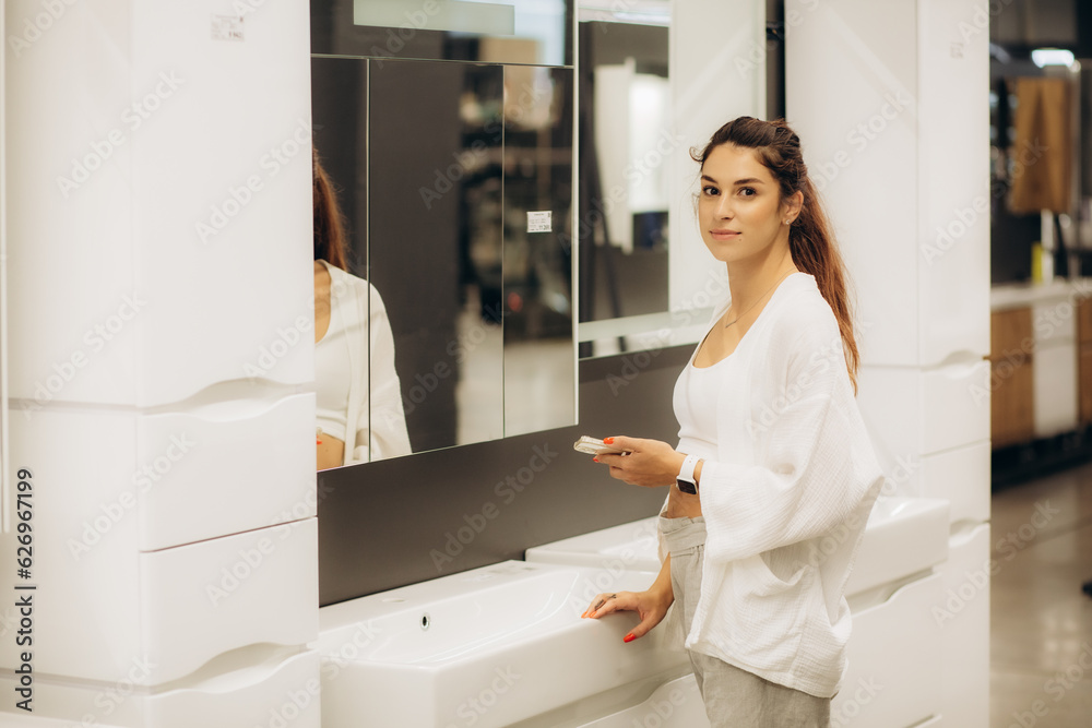 a woman in a mirror shop chooses a mirror a woman in a mirror shop chooses a mirror