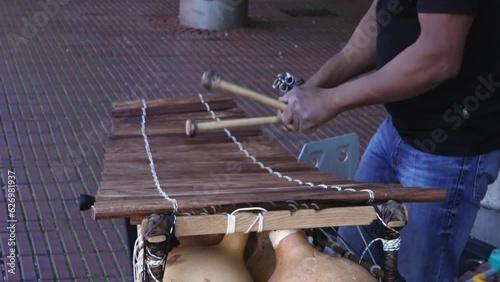 Xylophone play in slow motion, percussion instrument concept - street performer play onb wooden bars with mallets in hands photo