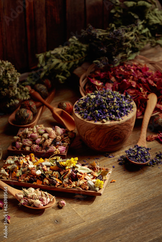 Various dried medicinal plants, herbs, and flowers on an old wooden background. © Igor Normann