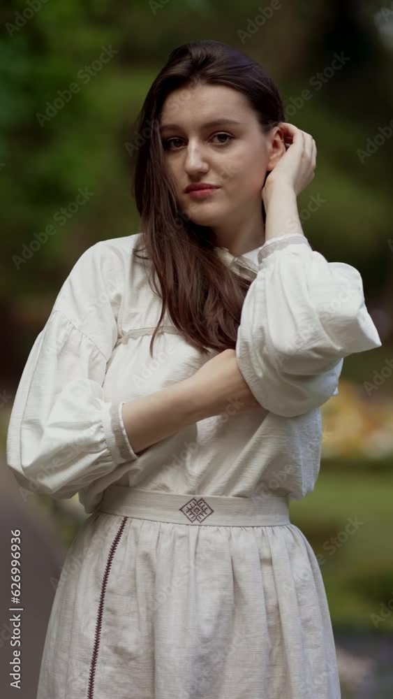 Portrait brunette pretty woman with full lips touching hair on park, fixing flexing hairstyle. Vertical orientation. Beauty and organic hair care treatment, cosmetics, shampoo Portrait brunette pretty woman with full lips touching hair on park, fixing flexing hairstyle. Vertical orientation. Beauty and organic hair care treatment, cosmetics, shampoo