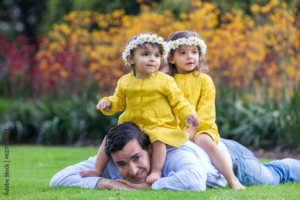 Fototapeta premium Young father having fun outdoors with his daughters. Fatherhood concept. Happiness concept. Family concept
