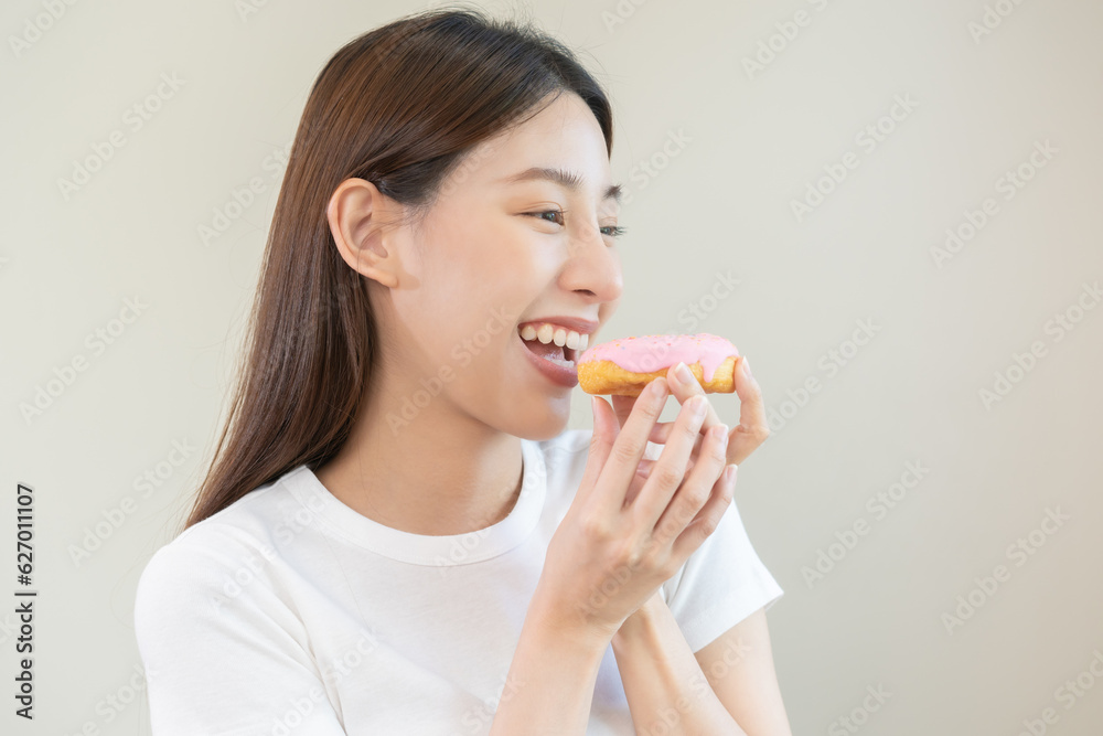 Portrait of attractive beautiful girl, pretty asian young teenage woman holding pink donut, doughnut, emotion enjoy sweet. Dieting, diet for loss weight to slim. Isolated white background, copy space. Portrait of attractive beautiful girl, pretty asian young teenage woman holding pink donut, doughnut, emotion enjoy sweet. Dieting, diet for loss weight to slim. Isolated white background, copy space.