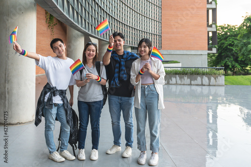 A group of homosexual people wearing their wrists and holding a flag showing the LGBT symbol, colling for equal rights for LGBT people. photo