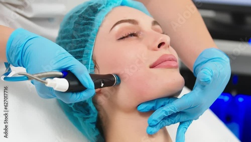 Beauty therapist performing hydrafacial procedure on woman photo