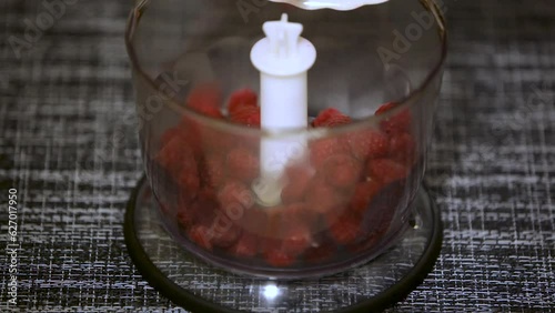 Ripe raspberries fall into the blender, close-up.