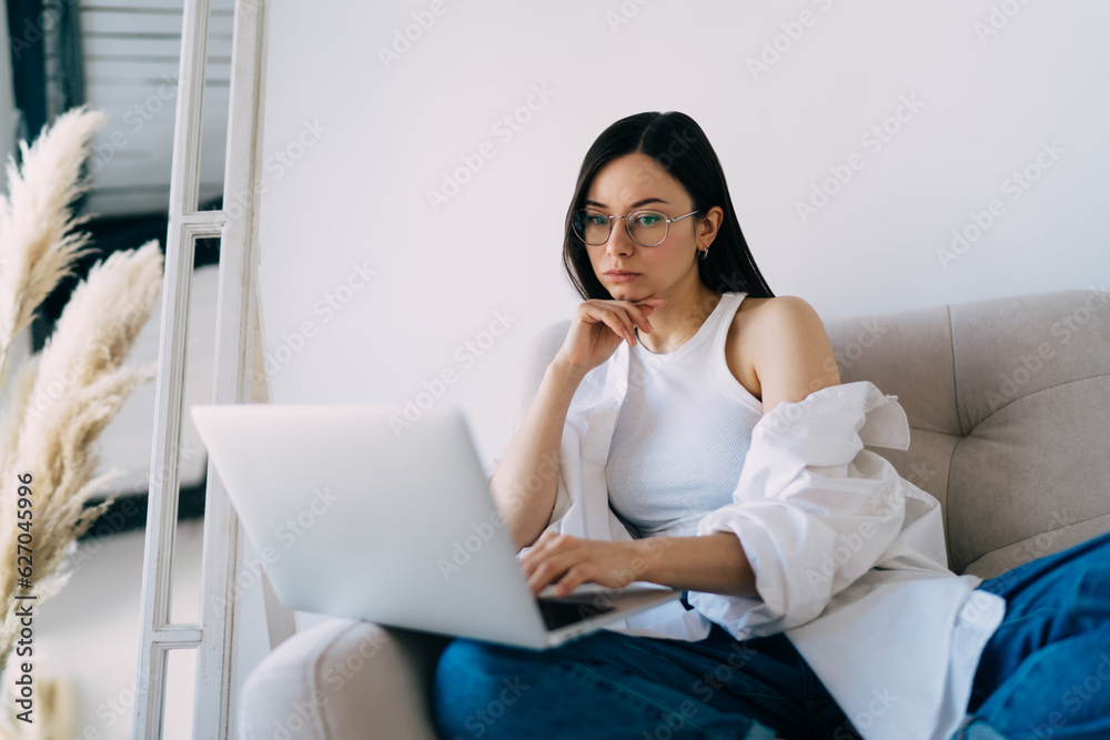 Focused woman using laptop during online webinar Focused woman using laptop during online webinar