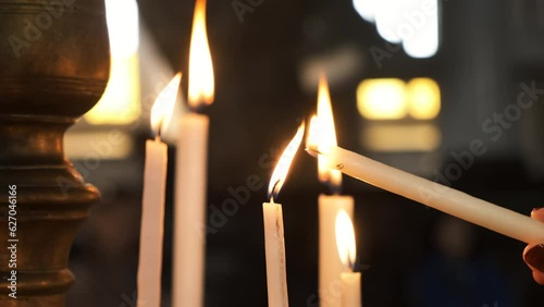 Burning Candles in Church. People Praying in Ritual. One Person Lit the Candle. 4K Prores Handheld Slow Motion Shot.