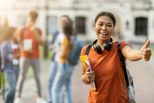 Study Abroad. Happy Black Female Student Posing Outdoors And Showing Thumb Up