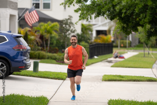 sport fit man jogging outdoor. running happy man races down the neighbourhood. running man enjoys freedom of running outdoor. The running man feels sense of joy during the run. lifestyle concept