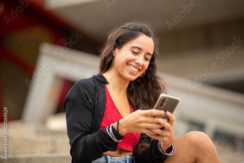 smiling woman sitting with mobile phone