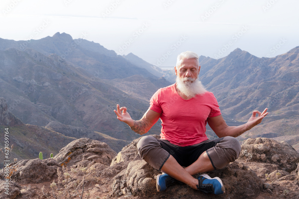 Senior athlete man greeting sunrise and meditating, mindful living and healthy wellbeing concept Senior athlete man greeting sunrise and meditating, mindful living and healthy wellbeing concept