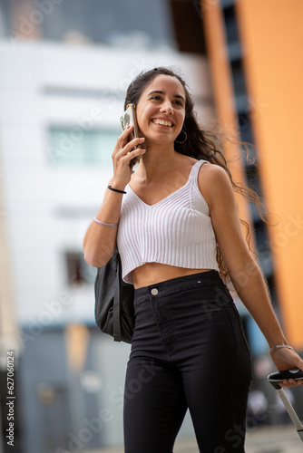 smiling young travel woman walking and talking on phone
