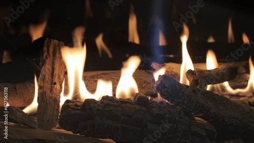 Burning gas fireplace with firewood close-up