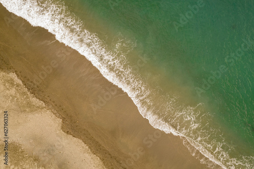 Coast line. Waves in the sand. Aerial view of waves on the beach. Textures and colors of sea and sand on the coast. Andalusia. Spain.