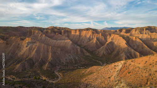 Gorefe desert. Panoramic aerial view of canyons  badlands  dusty road and rocky desert. Uninhabited desert landscape with colorful sunset. Gorafe. Spain.