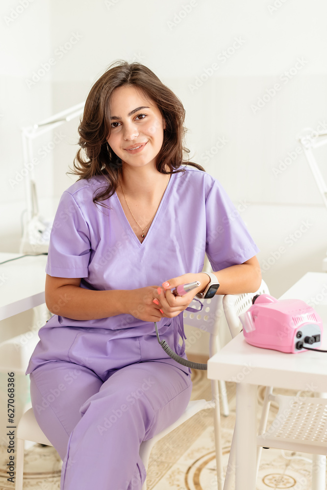 manicure and pedicure specialist waiting for clients in a beauty salon, making appointments, answering clients, training, work break, young multiracial girl in purple work suit , young entrepreneur manicure and pedicure specialist waiting for clients in a beauty salon, making appointments, answering clients, training, work break, young multiracial girl in purple work suit , young entrepreneur