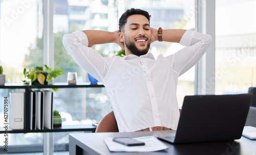 Laptop, relax and happy business man stretching at a desk after deadline, project and review satisfaction in office. Smile, stretch and Mexican male manager relieved with online development or result