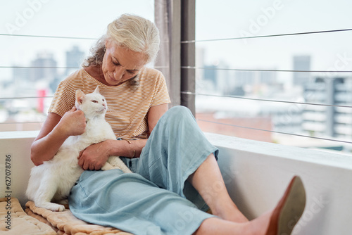 Cuddles keep the heart content. Shot of a mature woman spending quality time with her cat on the balcony at home.