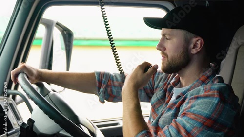 Trucker Preparing For Trip. Caucasian Men Talking on CB Radio. Truck Driver Job. Right Hand Drive Car photo